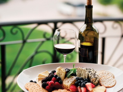 A table with a plate of dish and a wine bottle